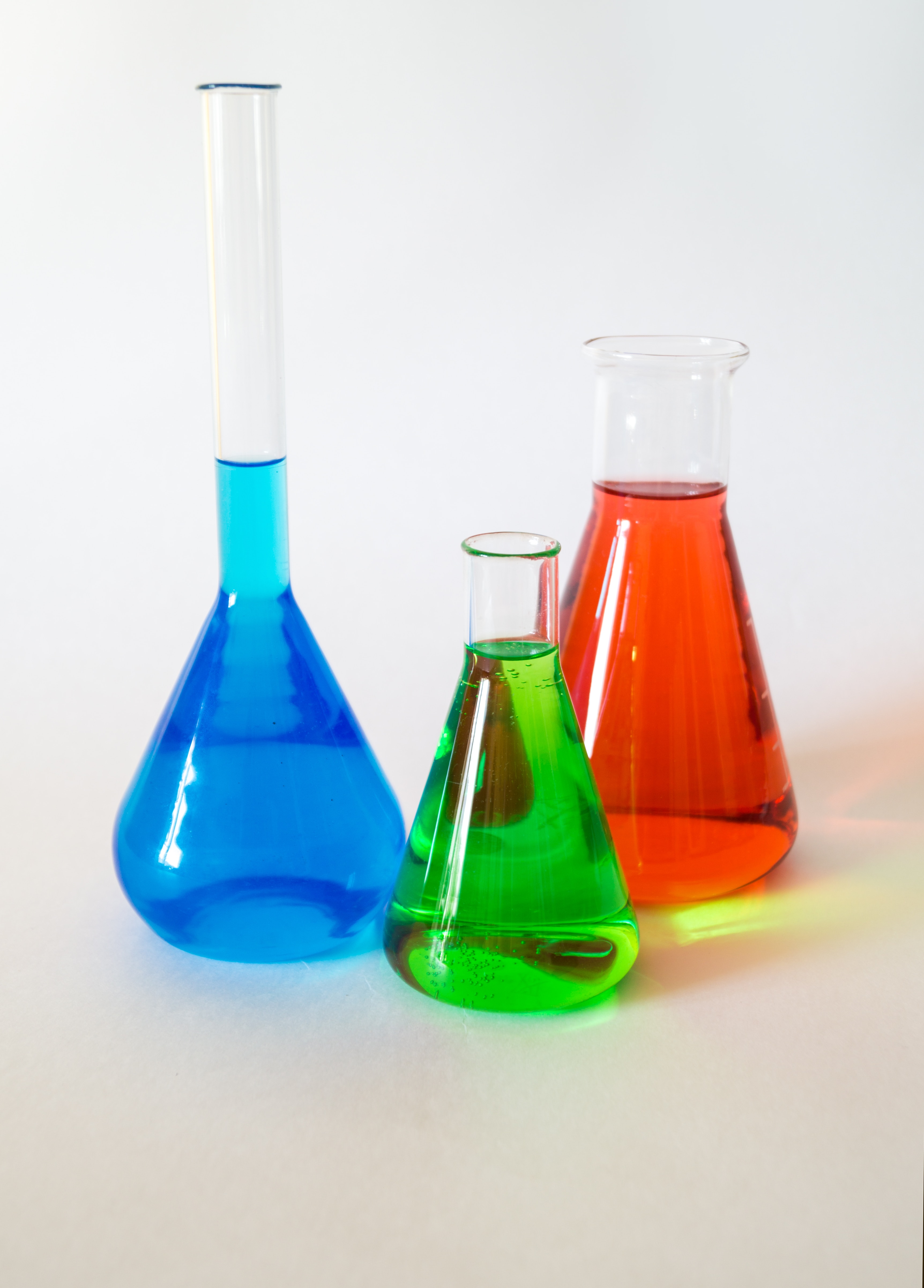 3 beakers with blue, green, and red liquid inside