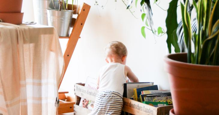 A toddler digs into a container of books