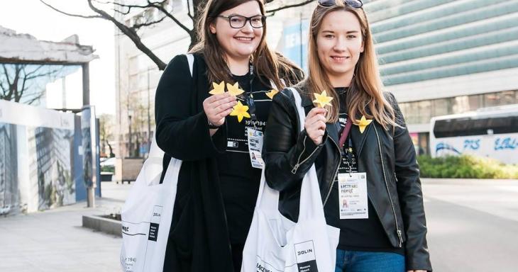 Young women holding paper daffodils 