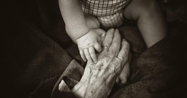 Old hand holding child's hand