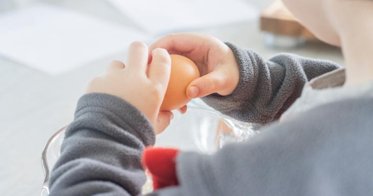 Child cracking an egg into a bowl