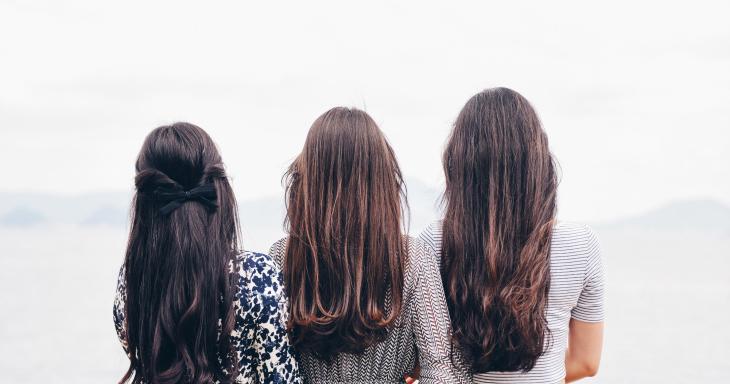 Three women looking at the ocean together