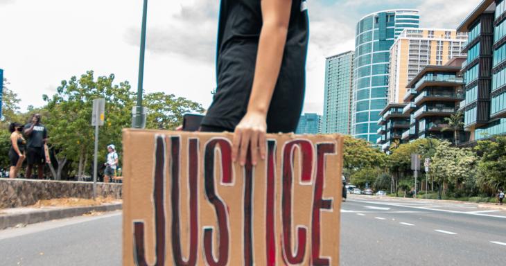 Woman holding sign reading "Justice"