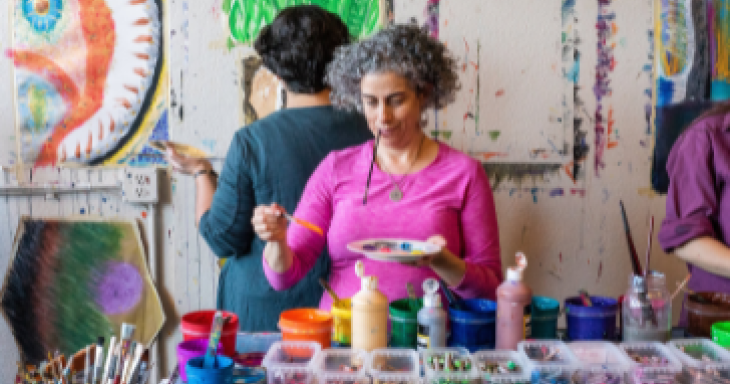 A woman uses a paintbrush