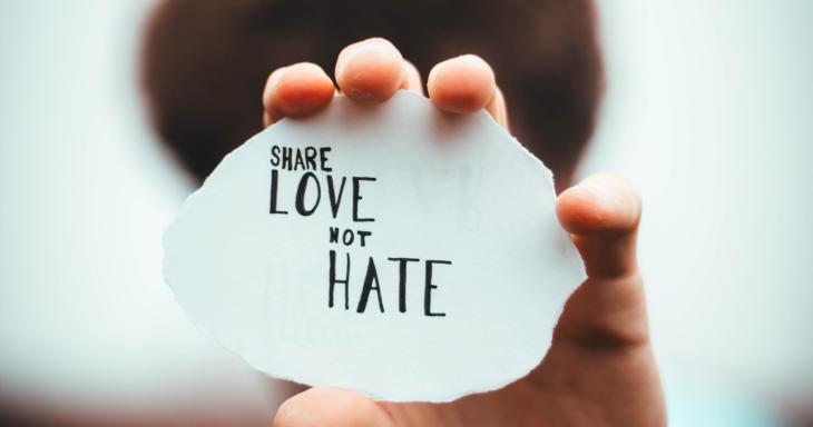 Person holding up a sign reading love not hate