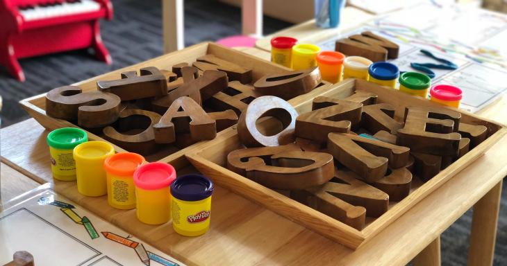 Table with wooden letters and playdoh. 