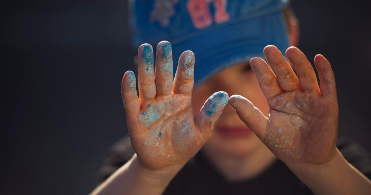 Child in baseball hat with raised hands