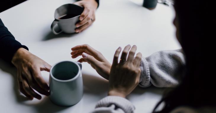 Hands of two people having coffee