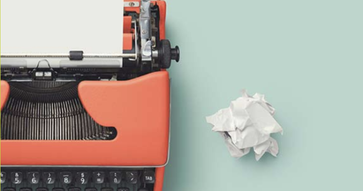A typewriter against a teal background, with a crumpled-up piece of paper next to it.