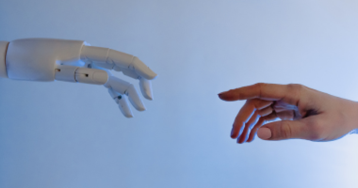 A robotic hand reaches out toward a human hand