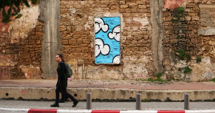 A window-shaped artwork, set in a wall in a street in Jerusalem. 