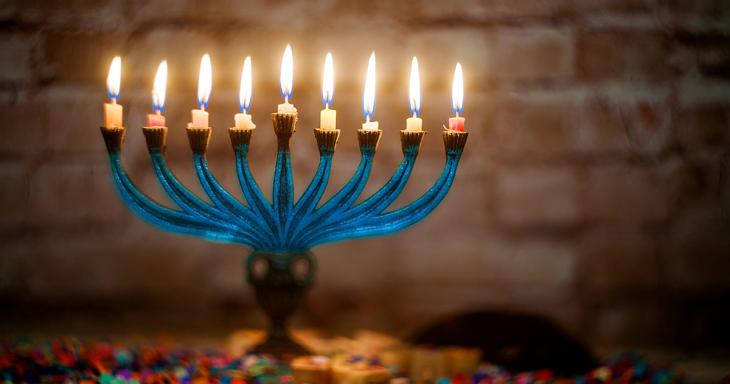 Beautiful blue menorah with all candles lit.