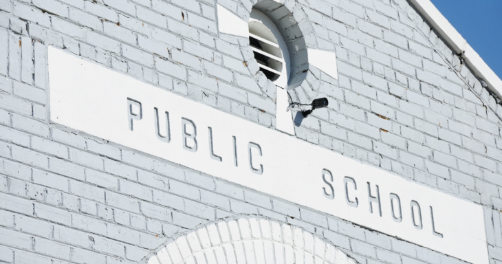 A gray building with the words Public School on a sign