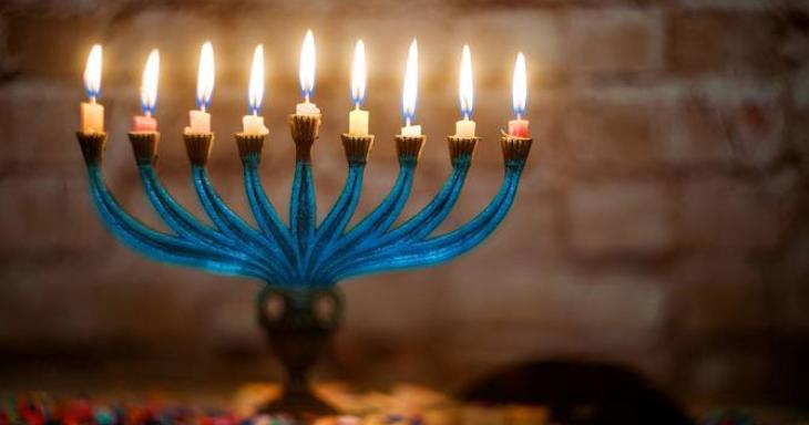 Menorah fully lit with confetti underneath