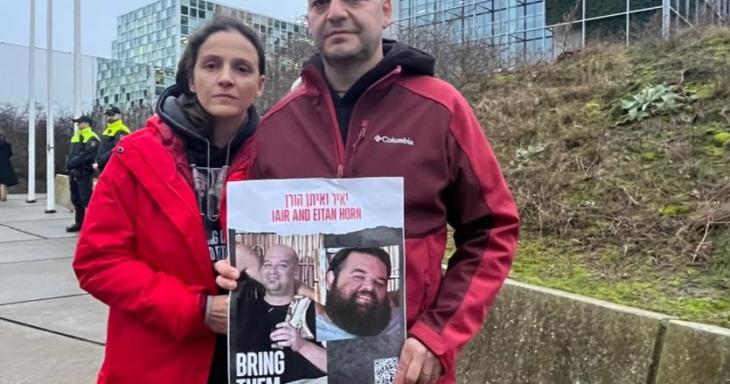 Dalia and her husband holding a hostage poster for her brothers-in-law in front of the UN building