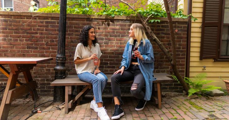 girls talking on park bench