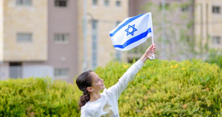 A young student holding an Israeli flag. 