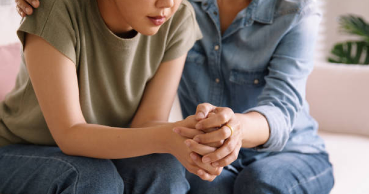 Teen and adult holding hands