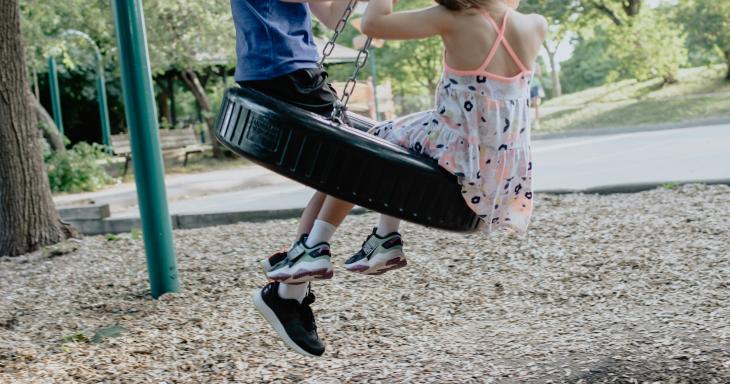 Two kids on tire swing