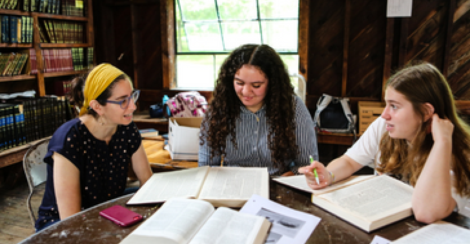 Women study Jewish text together inside