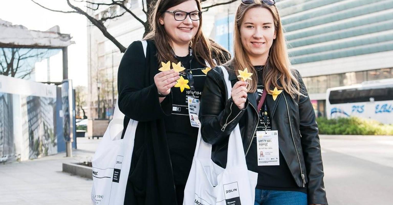 Young women holding paper daffodils