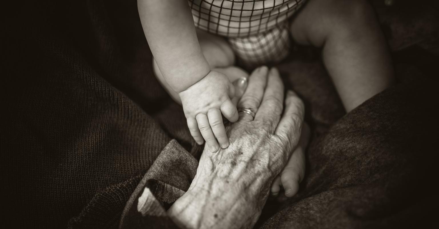 Old hand holding child's hand