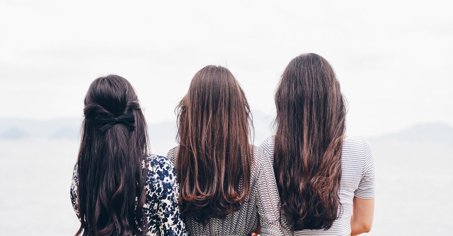 Three women looking at the ocean together