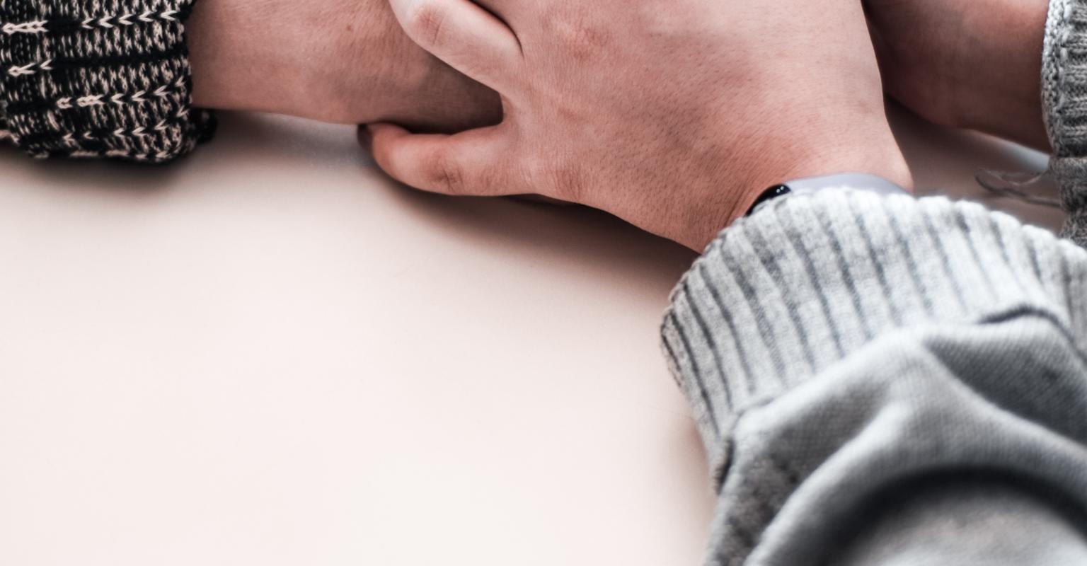 Hands holding from across a table