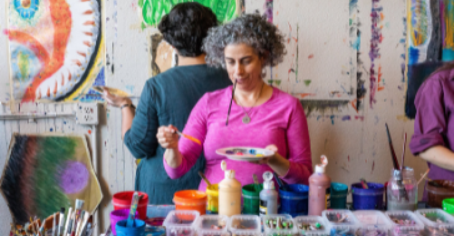 A woman uses a paintbrush