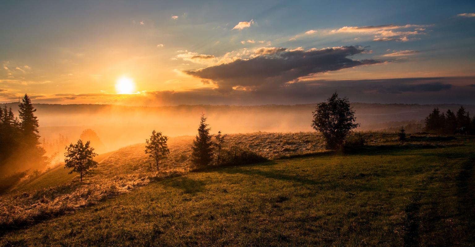 Sunset over a green hill
