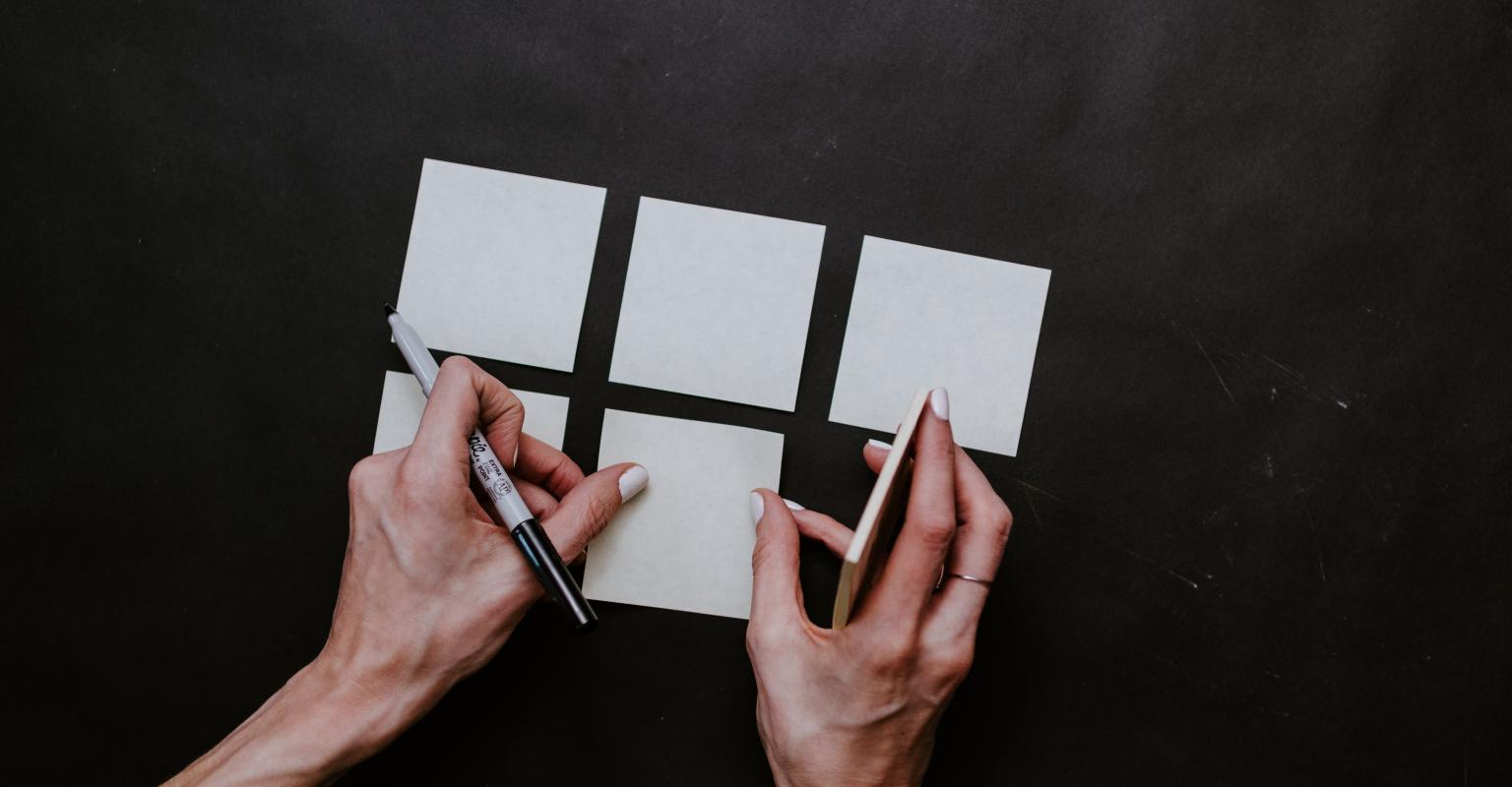 Person writing on sticky notes