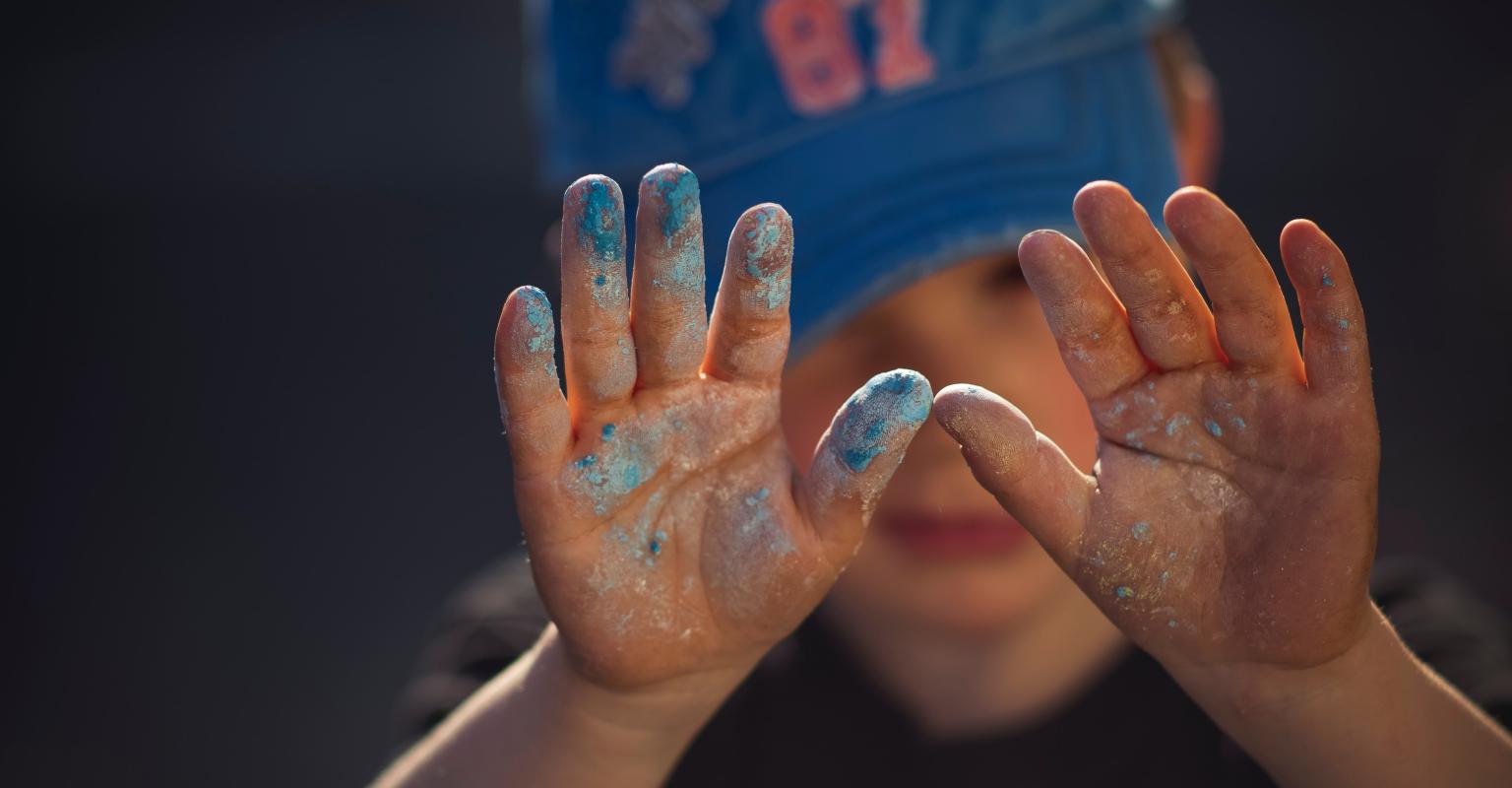 Child in baseball hat with raised hands