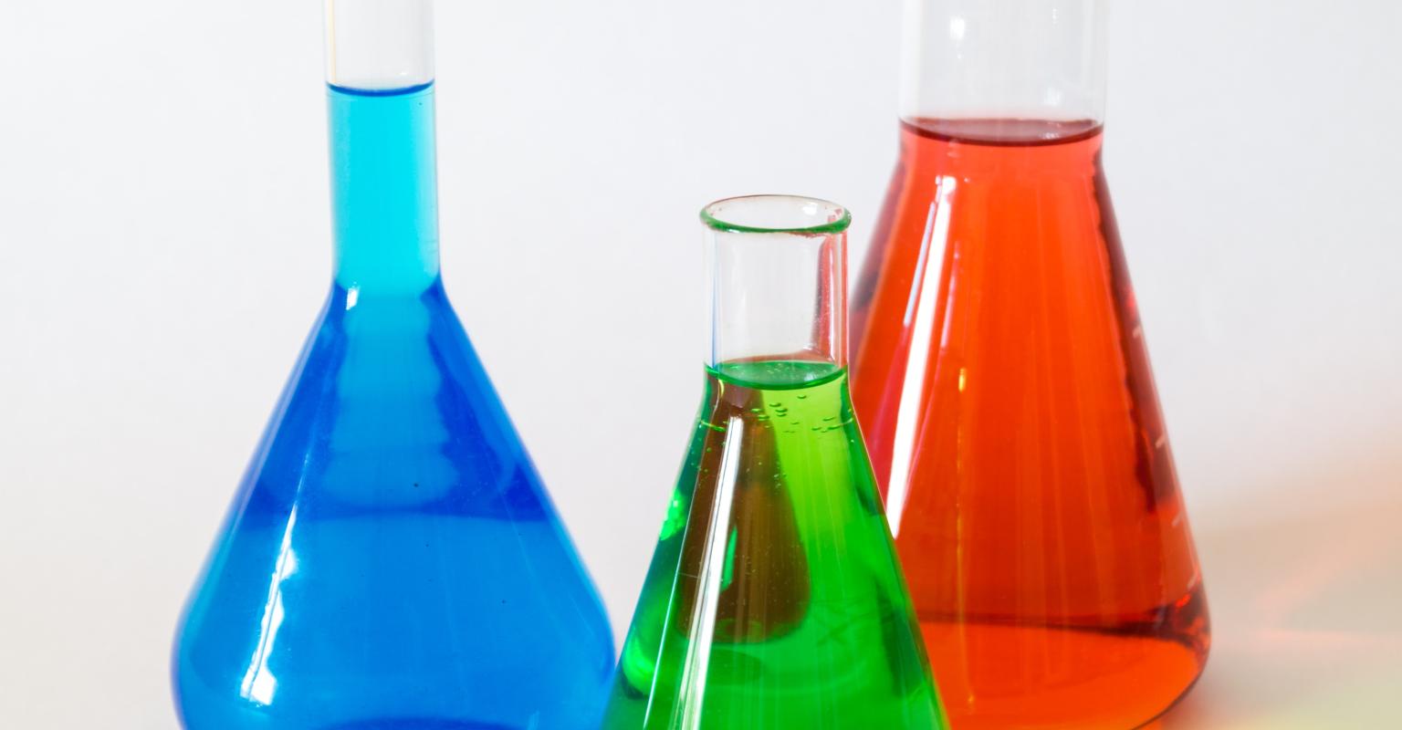 3 beakers with blue, green, and red liquid inside