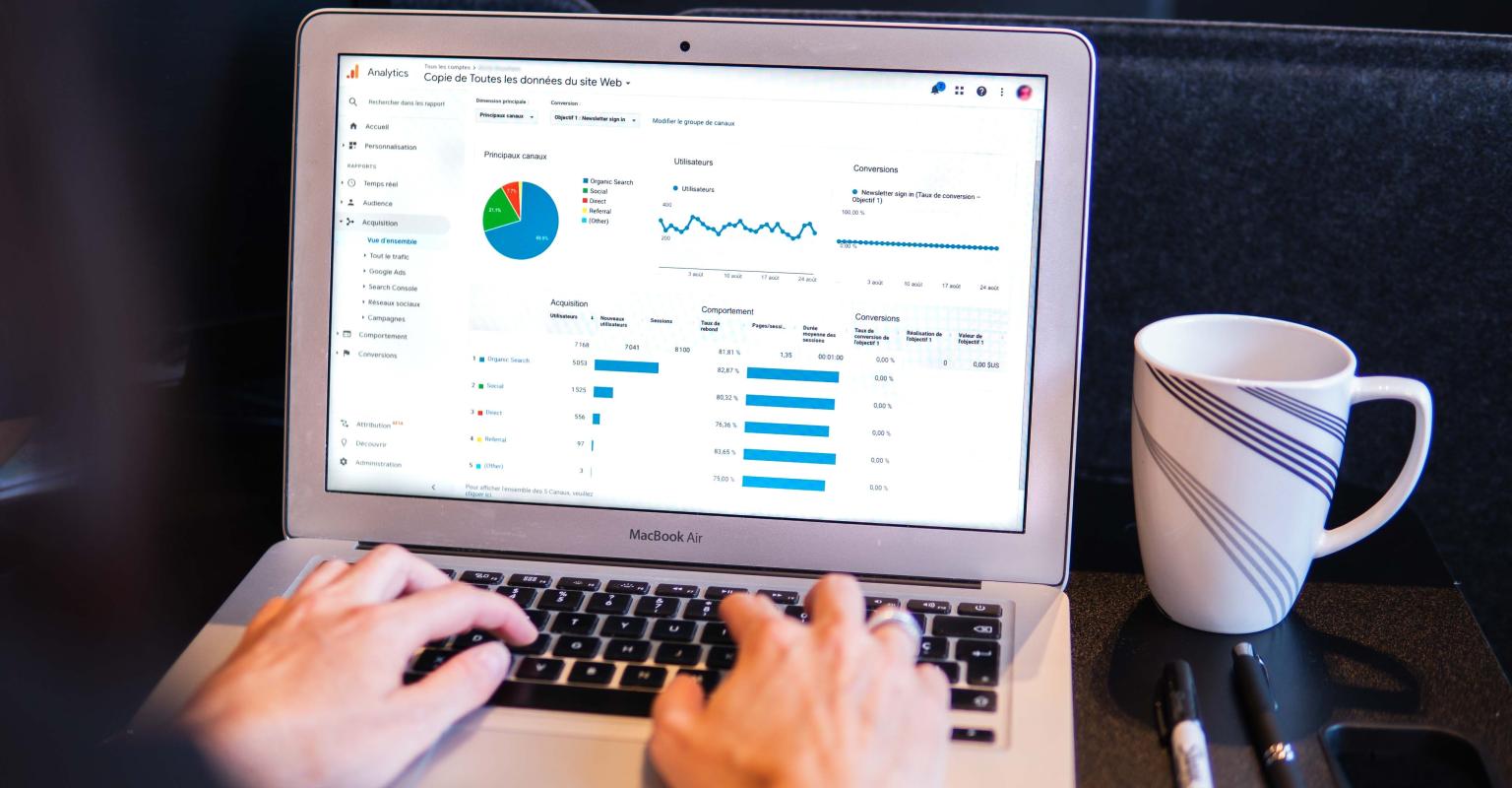 Someone using a laptop with data on the screen