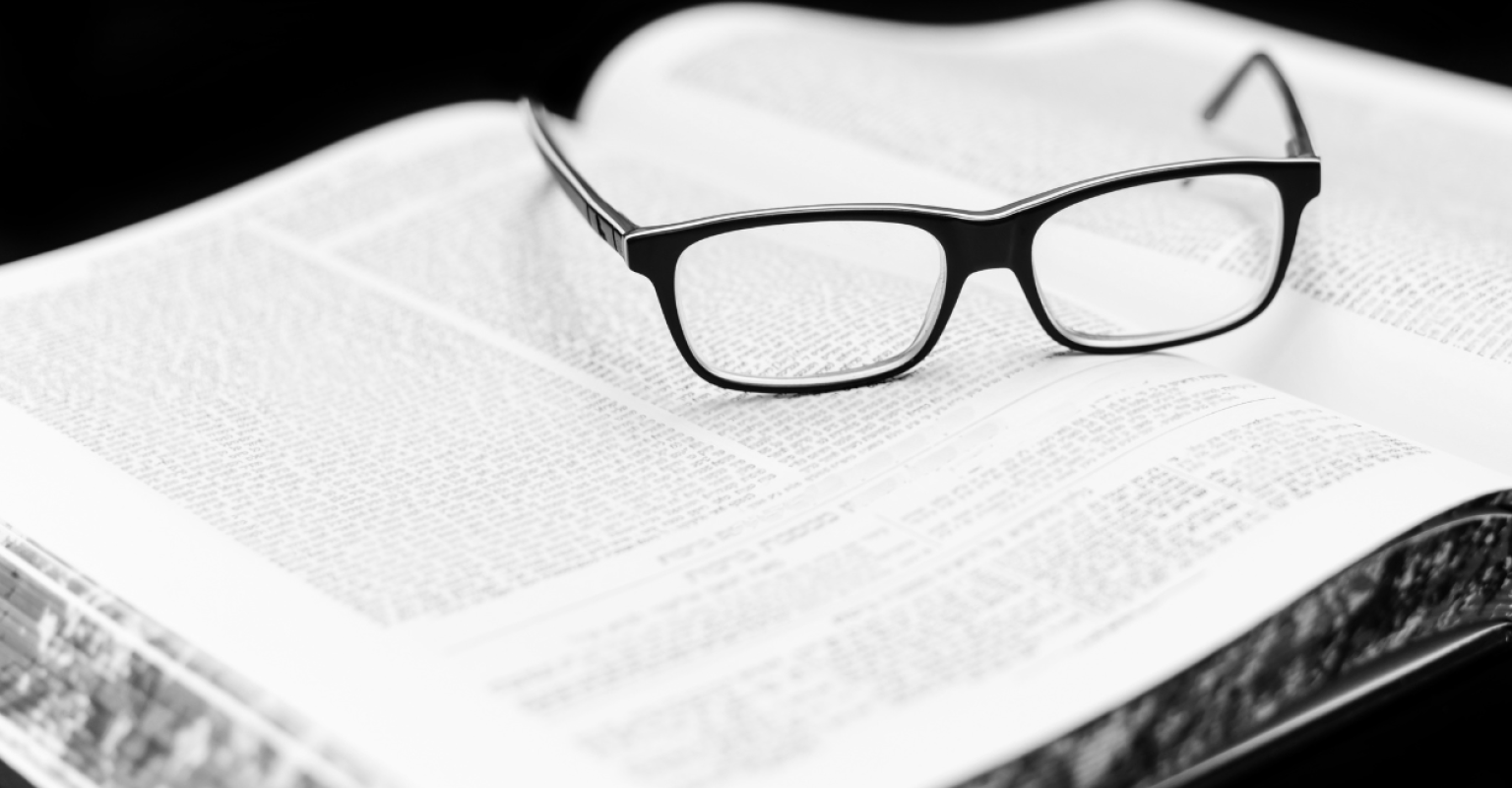 A pair of glasses rest on a book