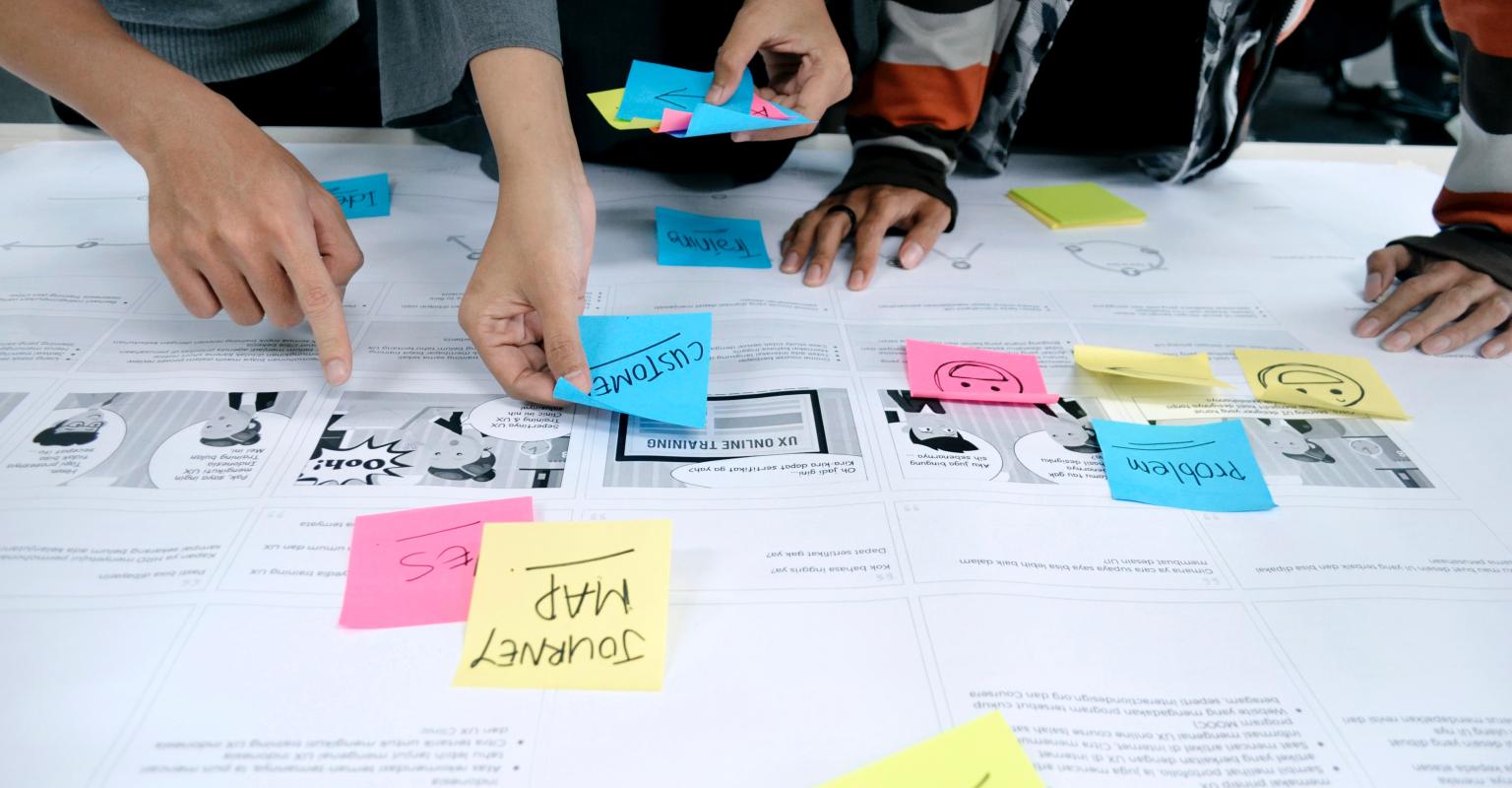 A group placing sticky notes in different colors on a table