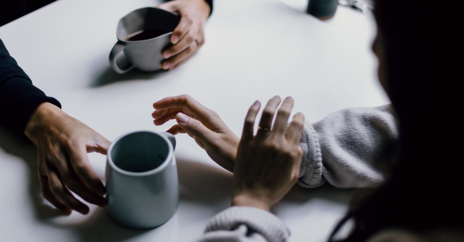 Hands of two people having coffee