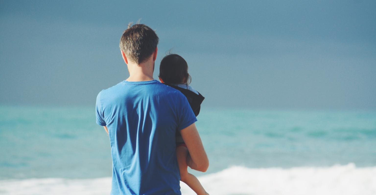 Parents and small child looking out at sea