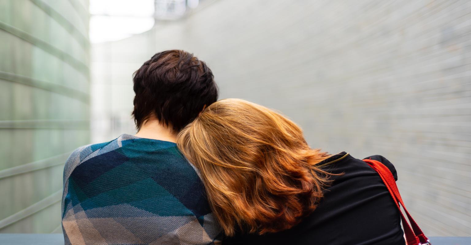 Two people leaning on each other