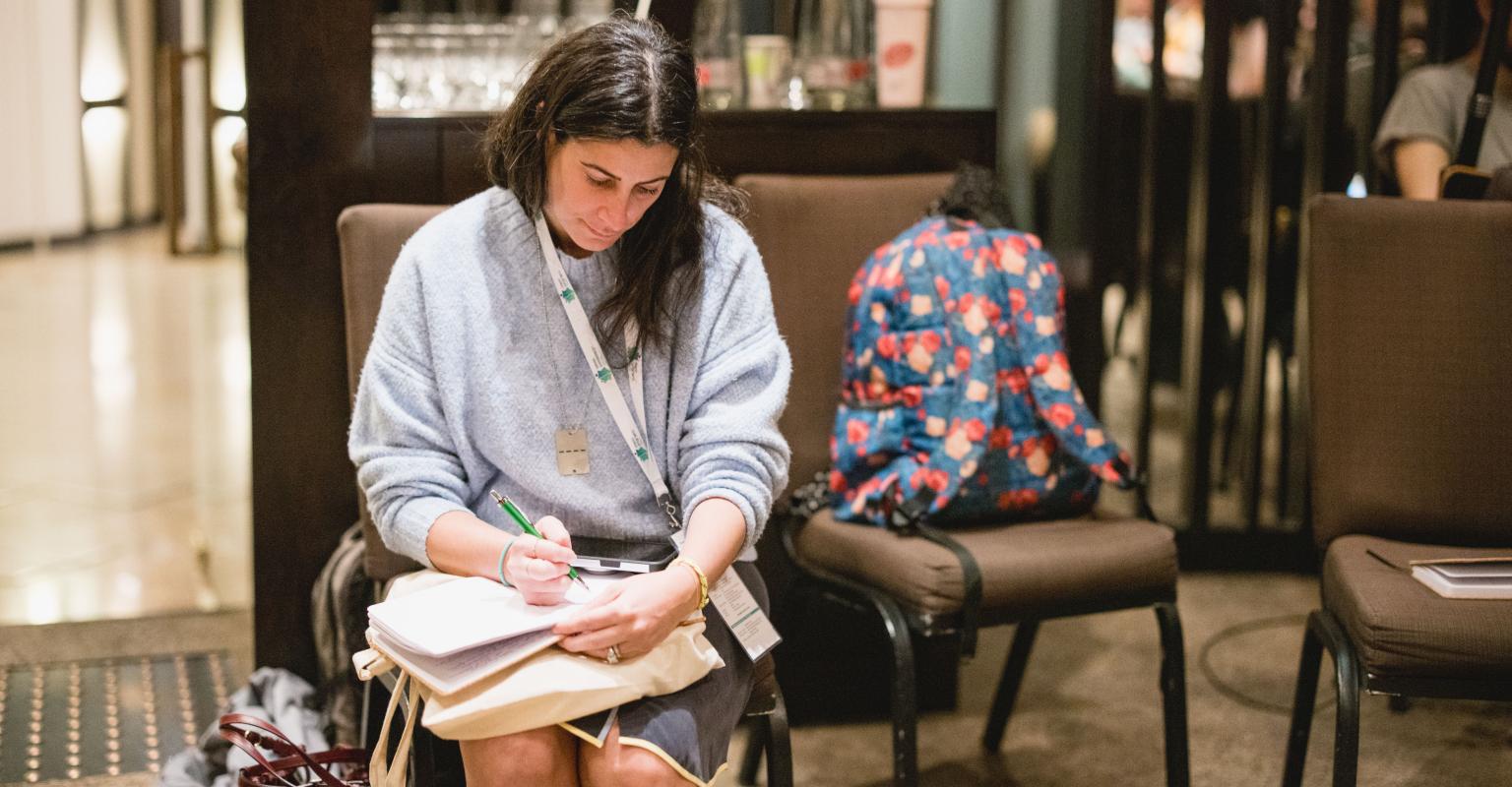 An educator sits and writes in a notebook