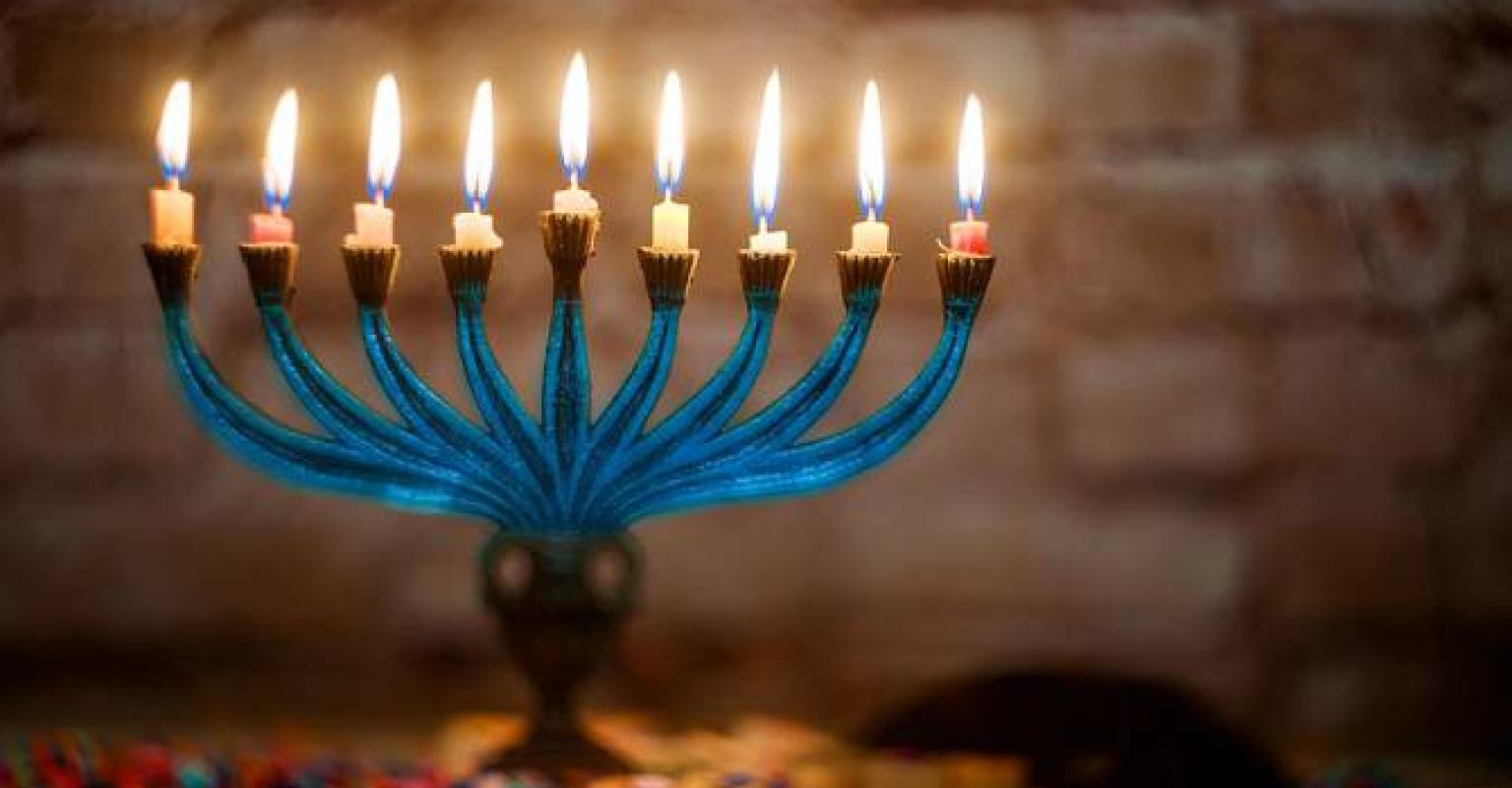 Menorah fully lit with confetti underneath