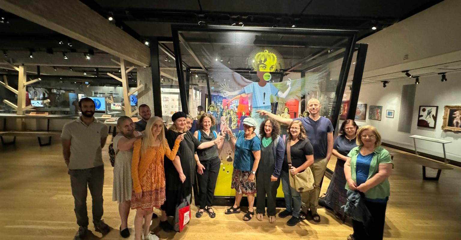 Groups of adults standing by a glass interactive at the ANU Museum