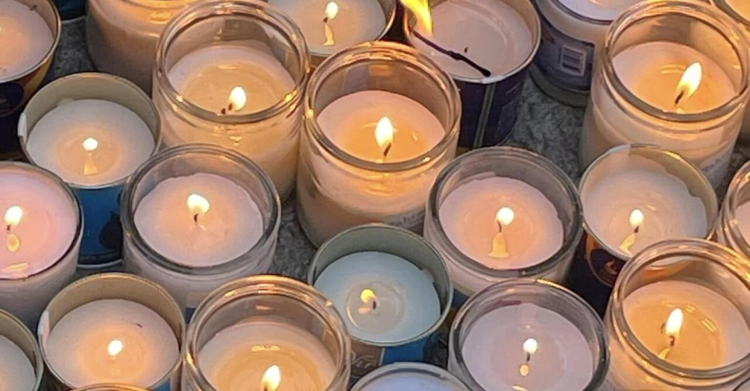 Cluster of lit candles on the ground
