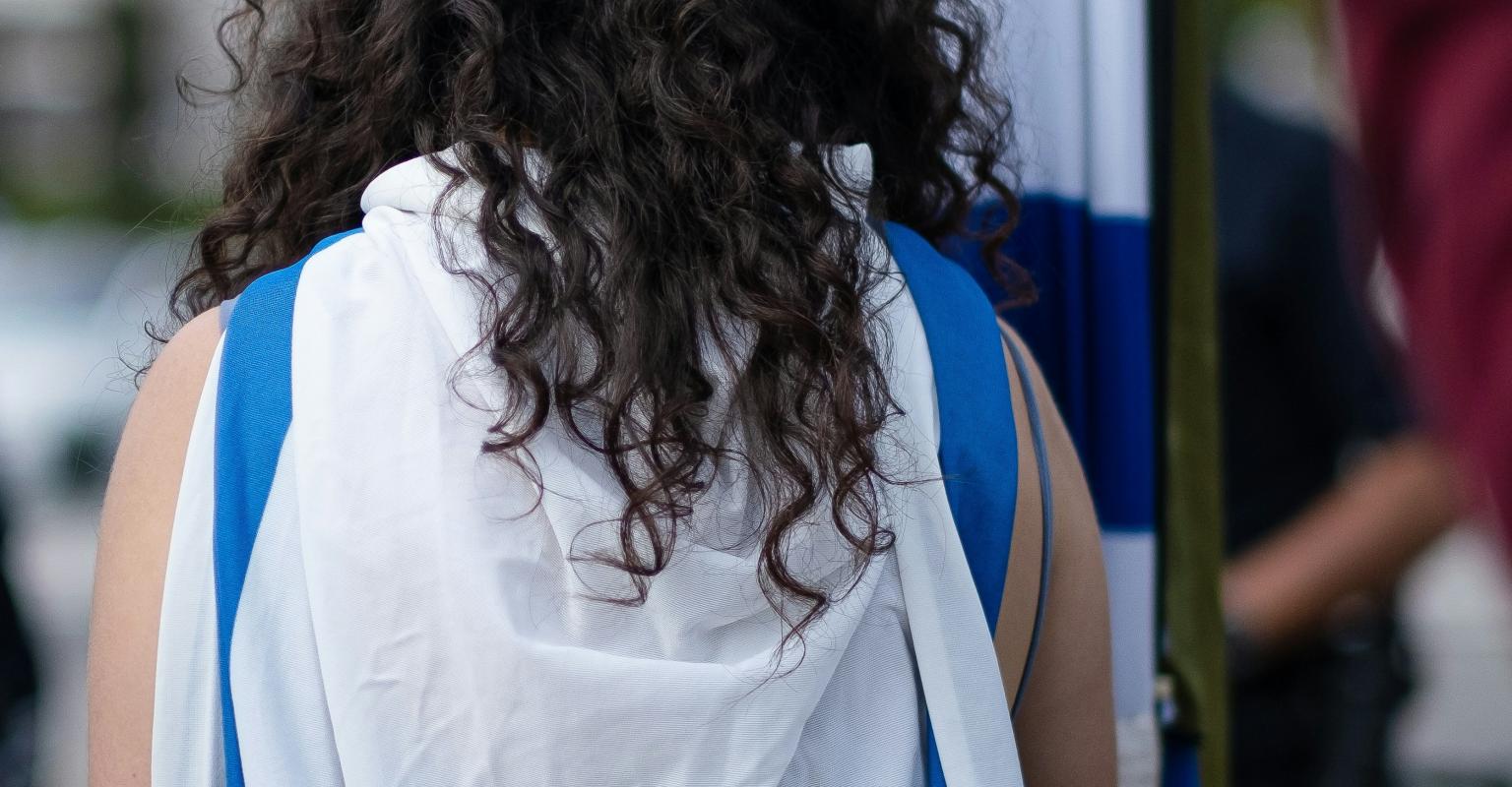 Woman wearing Israeli Flag as a cape, holding Israeli flag