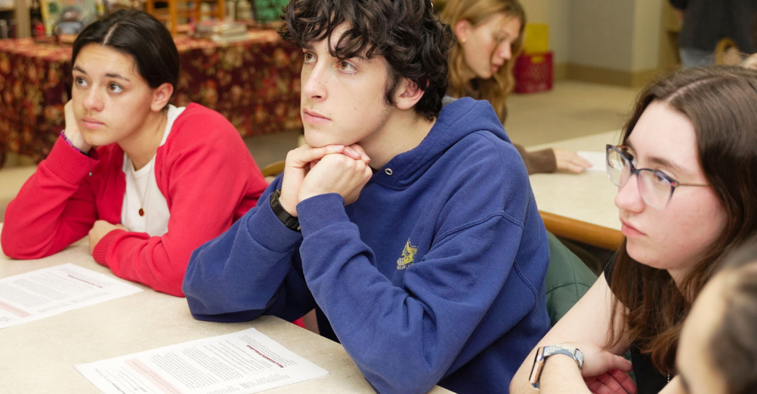 Three teens in thought sitting at a desk