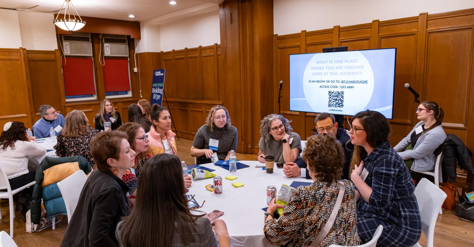 a group of educators sit around a table talking