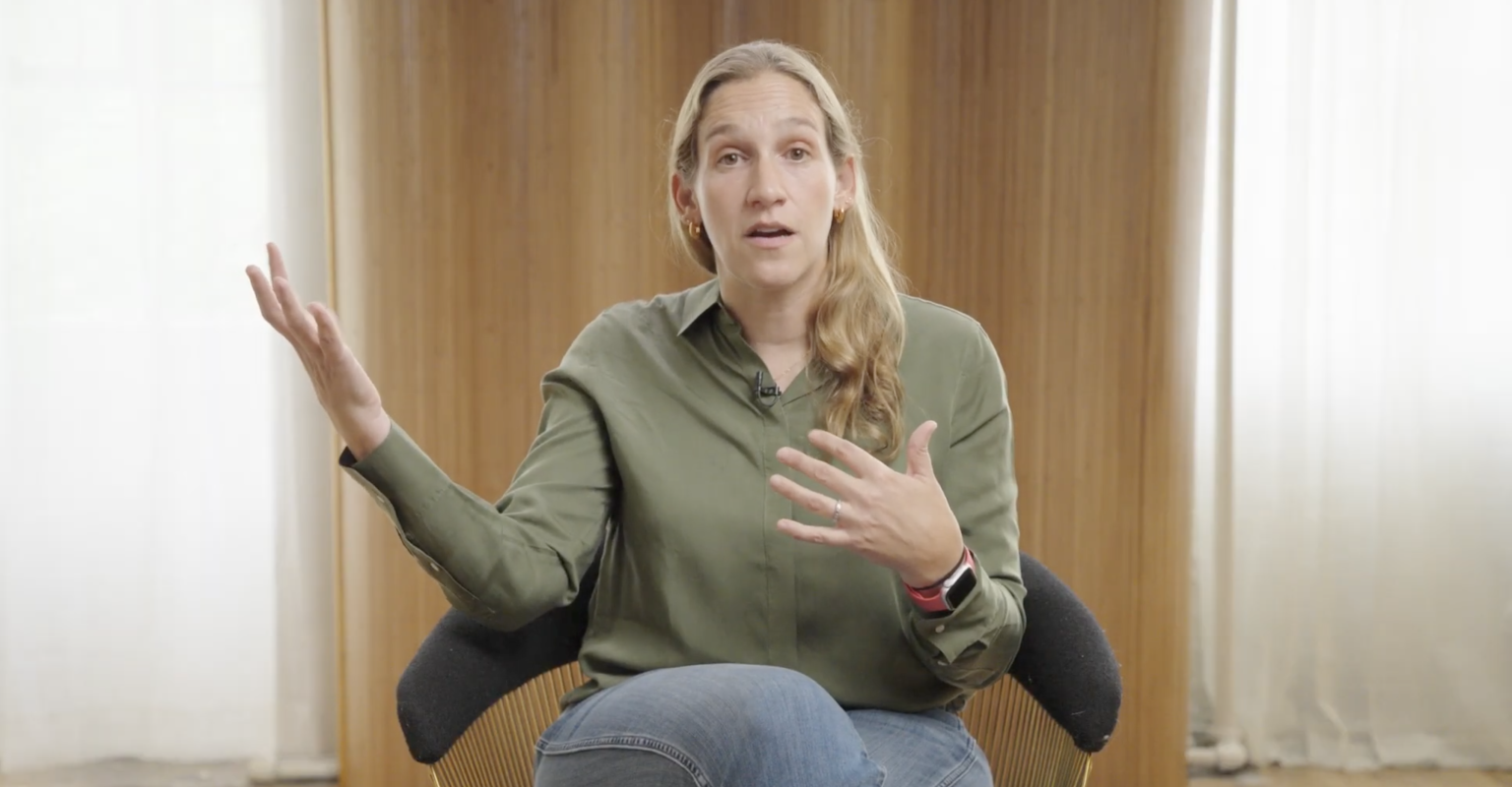 A woman sitting in a chair in mid-discussion