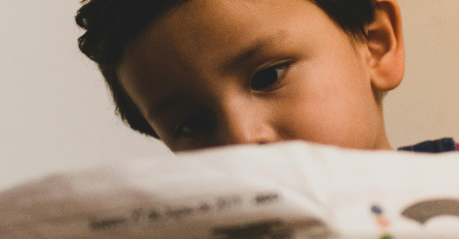 child reading newspaper