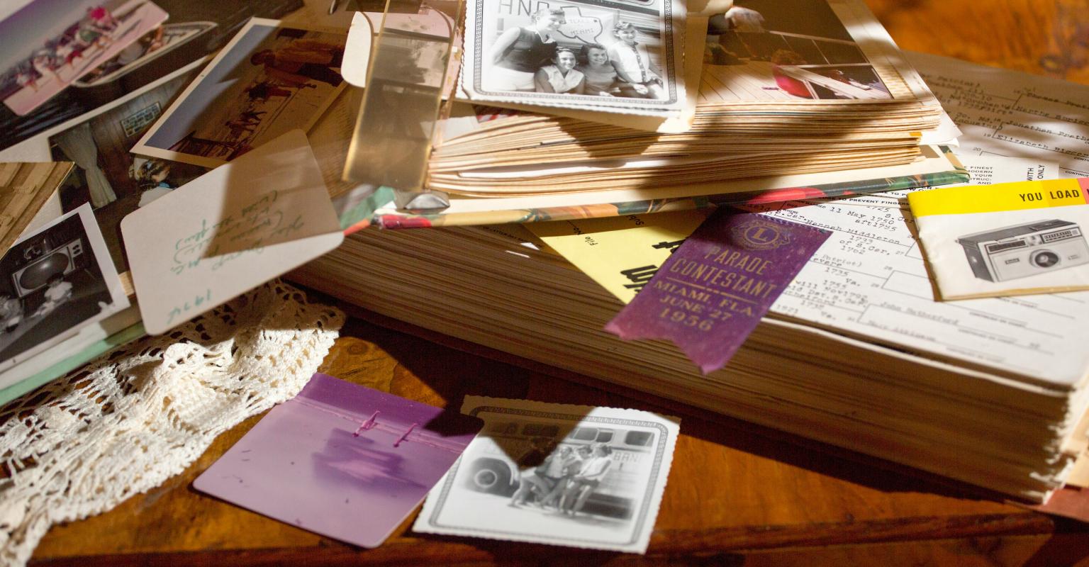 scrapbook, photographs, and other personal memorabilia sprawled on table