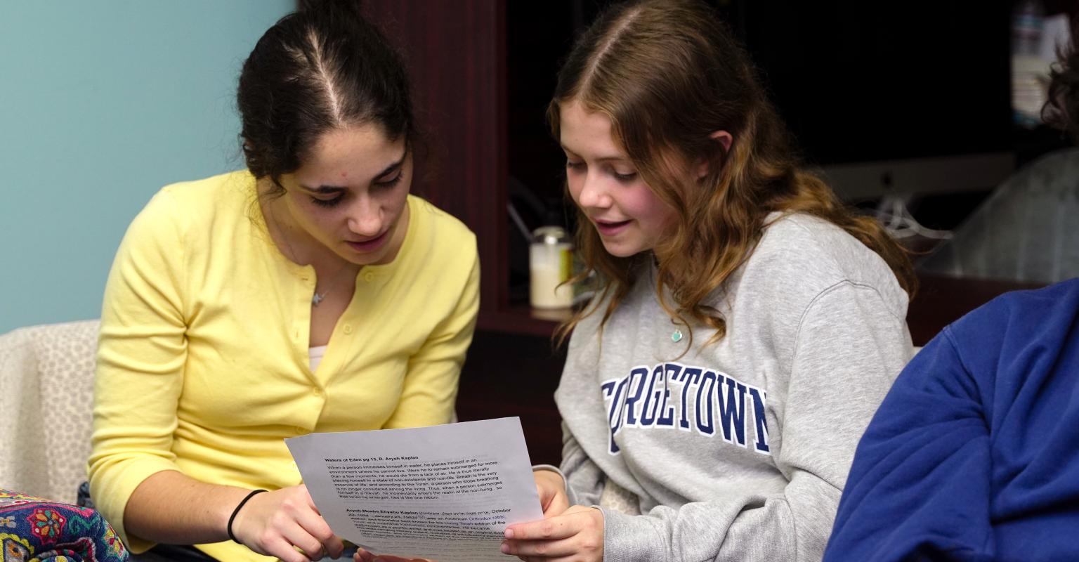 two students reading a text sheet together